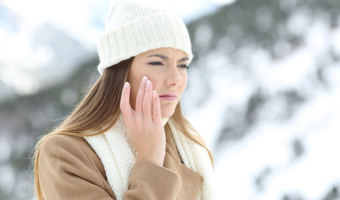 photo of woman in winter touching her face